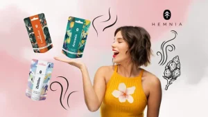 Smiling woman and a pack of CBD Hemnia flowers – the benefits and effects of hemp flowers for relaxation, creativity and inner balance