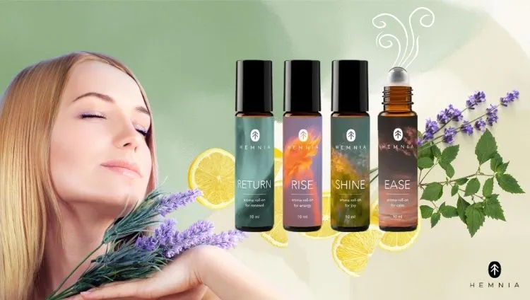 Ženska uživa v vonju sivke, ob njej so Hemnia Return, Rise, Shine in Ease roll-ons za aromaterapijo, logo Hemnia je spodaj desno